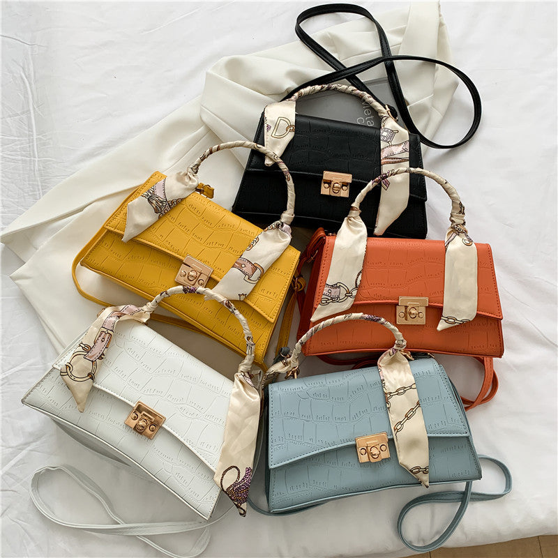 Collection of colorful handbags with ribbons on a white background